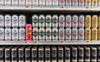 Store shelf of craft beer cans with similar designs and one distinct can standing out